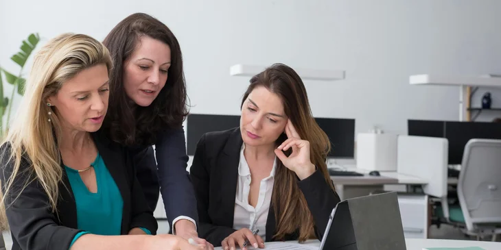 Employees reviewing the files of a newly hired employee.