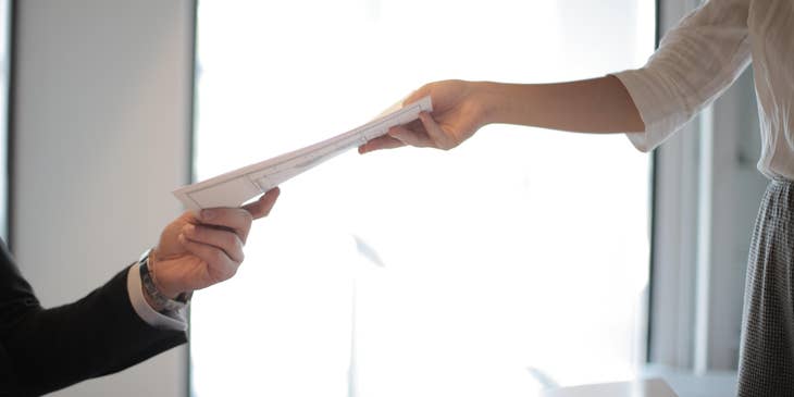 Person handing a form to another person