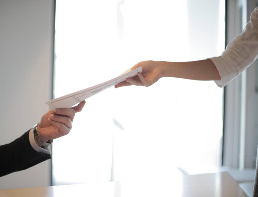 Person handing a form to another person