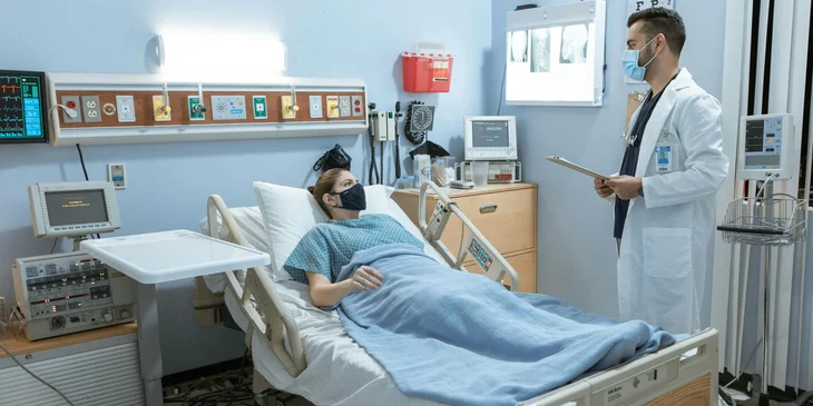 An endocrinologist giving medical advice to a patient lying on a bed.
