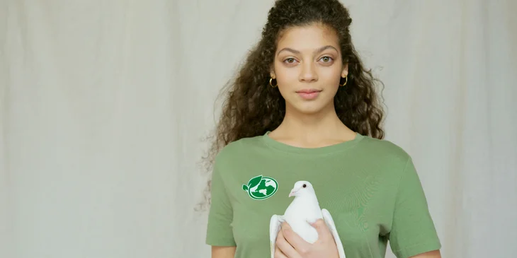 An environmentalist holding a white dove in their hands.