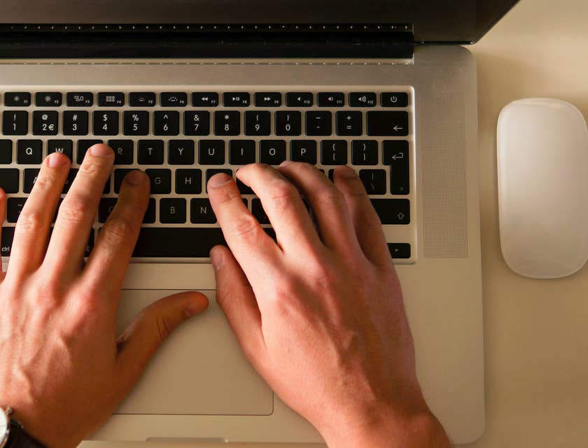 Una persona escribiendo en una láptop.