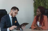 Dos personas en una oficina discutiendo estrategias de reclutamiento.