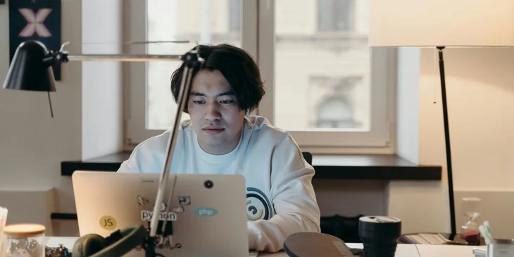 A data engineer working remotely on his laptop.
