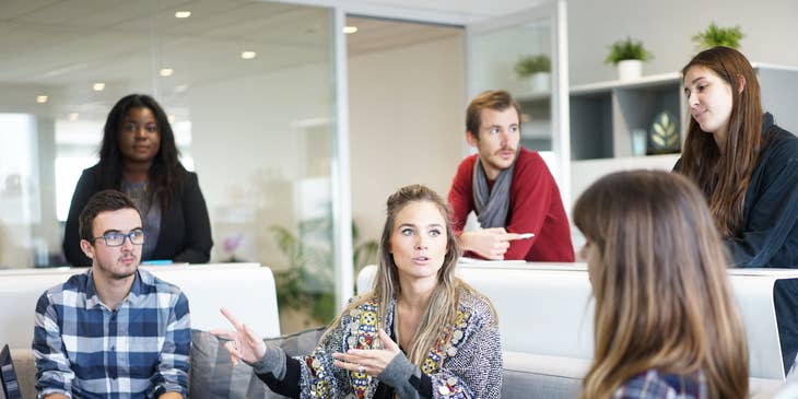 A group of colleagues discussing work in an office space.