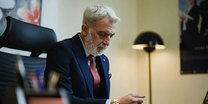 An executive reviewing a document in his office.