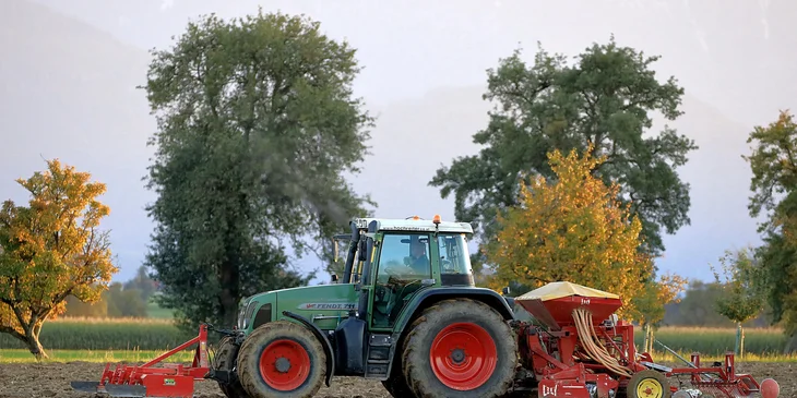 A farmer operating a tractor on a farm.