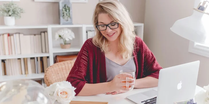 A fashion copywriter, smiling happily, looking down.