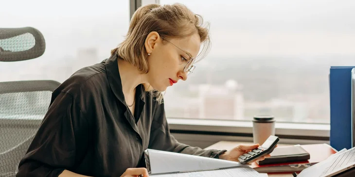 An accountant reviewing the documents at her desk.
