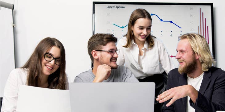 A group of professionals smiling and working at a fintech company.