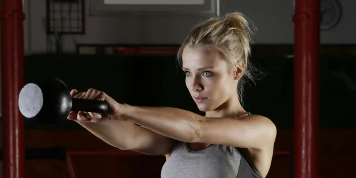 A woman holding an exercise equipment.