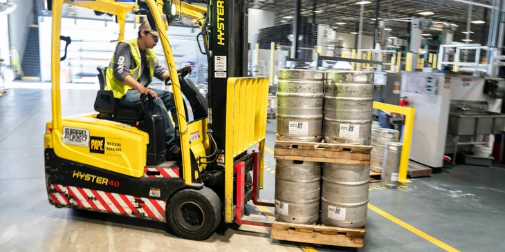 A forklift operator about to transport materials to a different location within the warehouse.