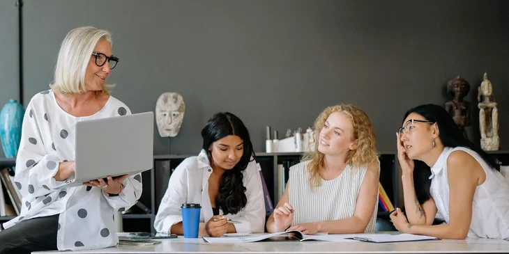 A group of women having a discussion in an office.