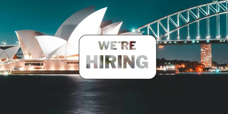 A sign that says "We're Hiring" in front of a famous landmark.