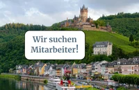 Ein Schild mit der Aufschrift „Wir suchen Mitarbeiter!“ vor einem berühmten Wahrzeichen.