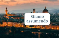 Un cartello che dice "Stiamo assumendo" davanti a un famoso punto di riferimento.