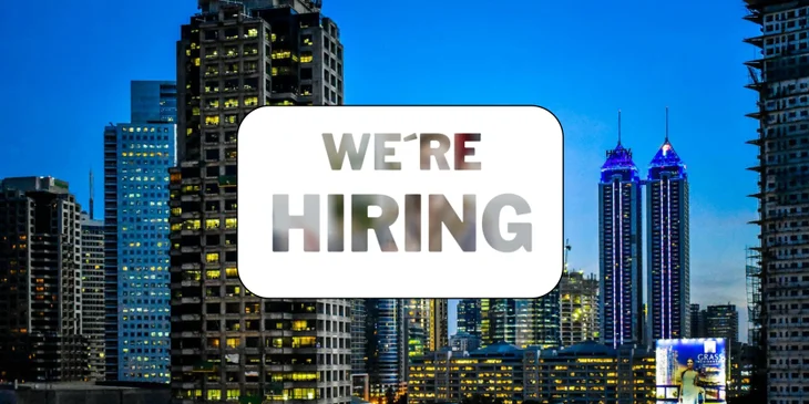 A sign that says "We're Hiring" in front of the Philippines skyline.