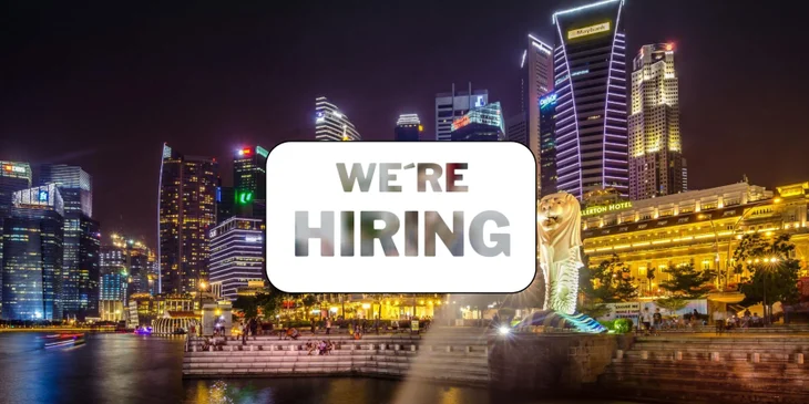 A sign that says "We're Hiring" in front of Merlion Park.