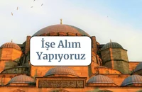 Ünlü bir dönüm noktasının önünde "İşe Alıyoruz" yazan bir tabela.
