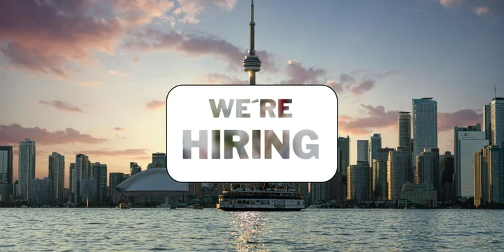 A sign that says "We're Hiring" in front of a famous landmark.