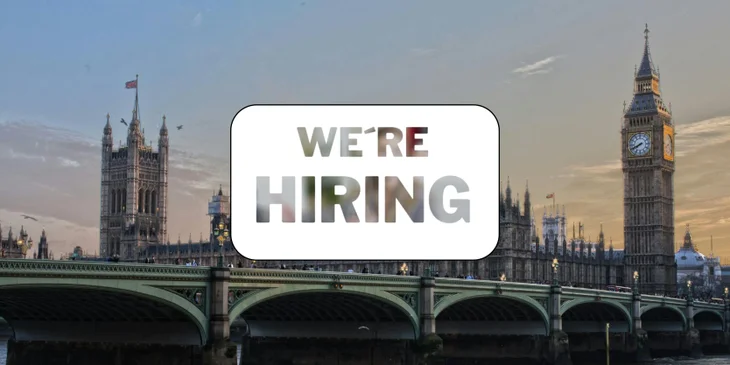 A sign that says "We're Hiring" in front of a famous landmark.
