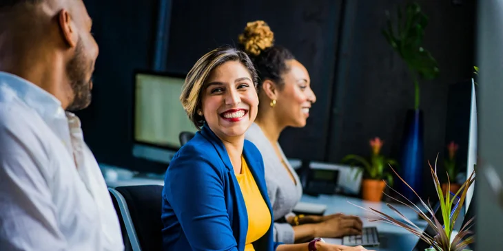 A woman happily working with her colleagues.