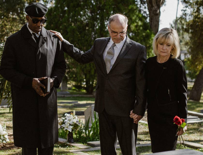 A funeral attendant comforting a grieving family.