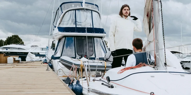 A man in a white shirt standing on a boat.