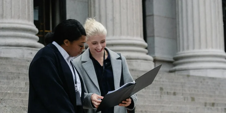 Two women standing outside a government establishment.