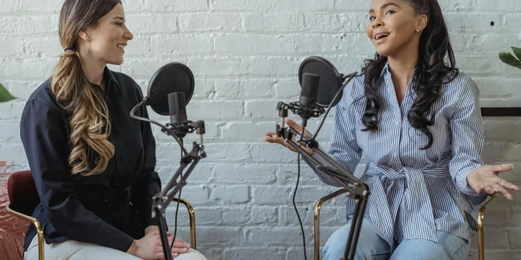 Two female broadcast journalists live on the radio.