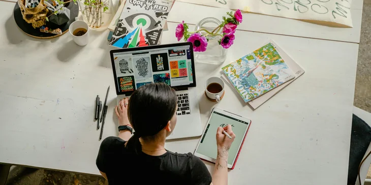 A graphic designer working at her desk on a design project.