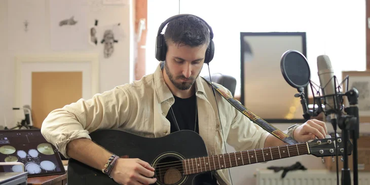 A guitarist tuning his guitar.