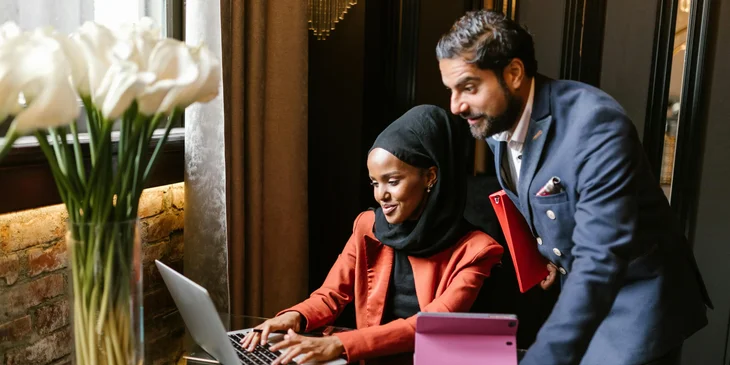 A man and woman working together using a laptop.