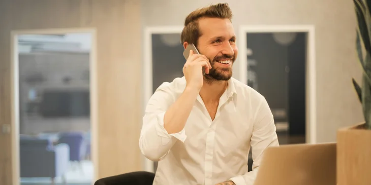 Un uomo seduto mentre parla con qualcuno al telefono.