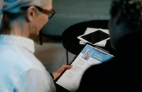Una reclutadora leyendo las habilidades de una candidata en su currículum.
