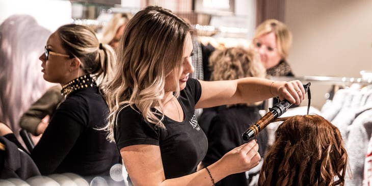 hair stylist curling a clients hair