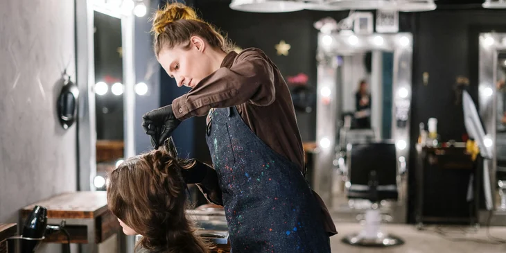 A hairstylist working with a client.