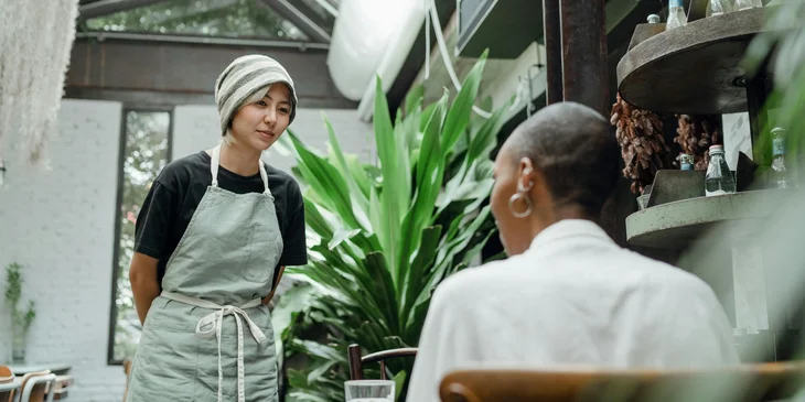 A waitress taking a food order from a customer.