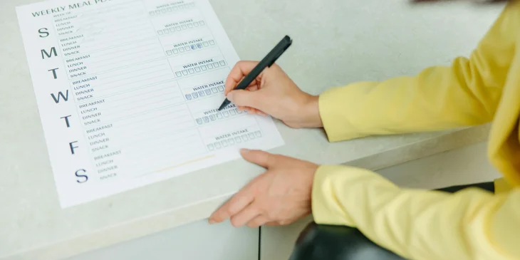 A health coach preparing a meal plan for her client.