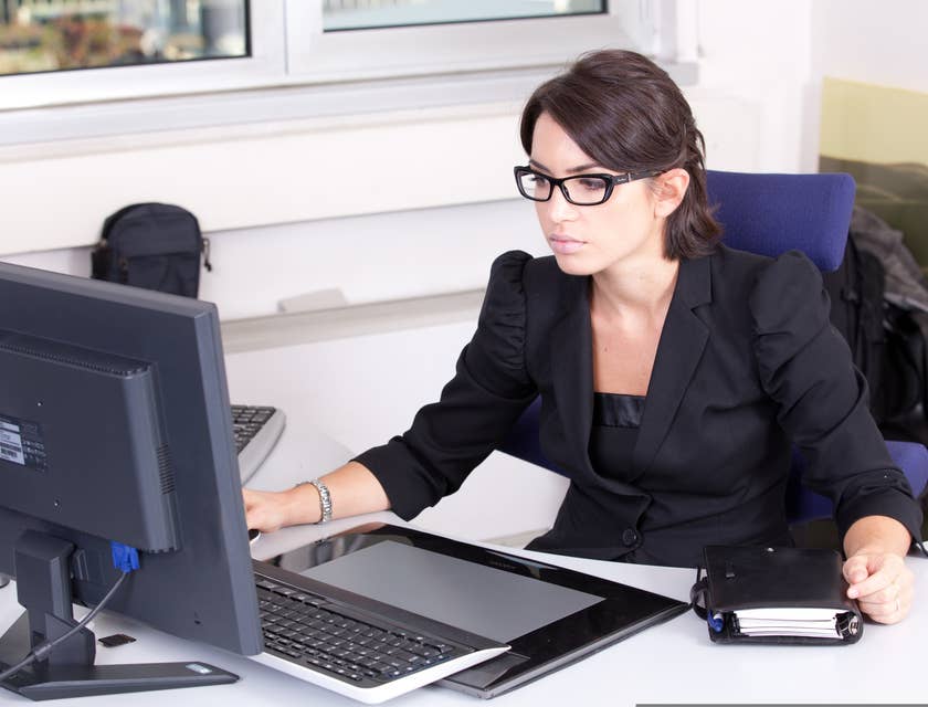 Una contadora trabajando en una computadora portátil y una agenda en el escritorio.