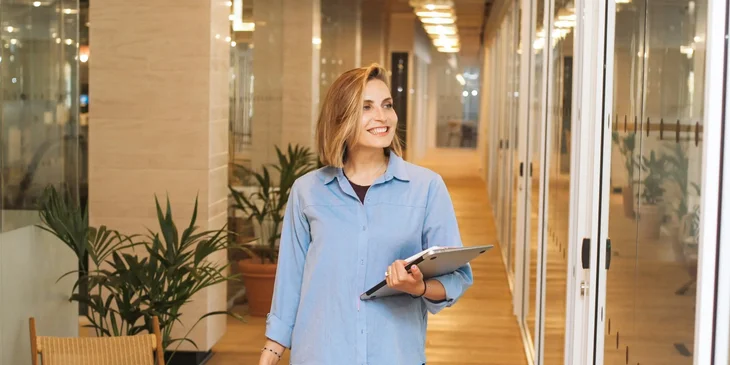 A woman walks down the office hallway.