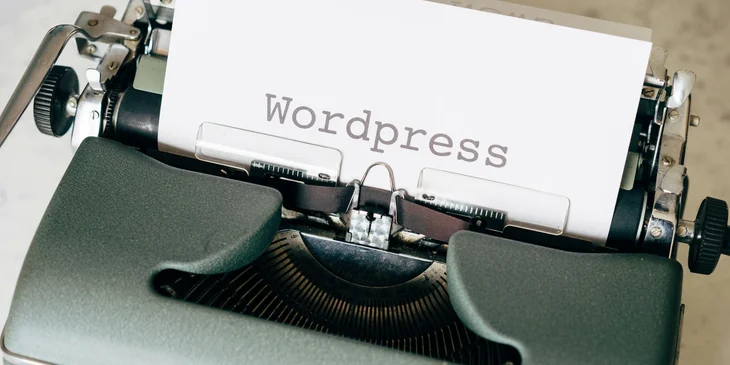 A typewritten word "Wordpress" on a sheet of paper in a typewriter.