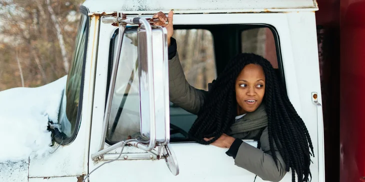 A female truck driver waiting for her companion before departing.