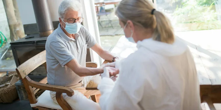 A home health nurse checking a patient's vital signs.