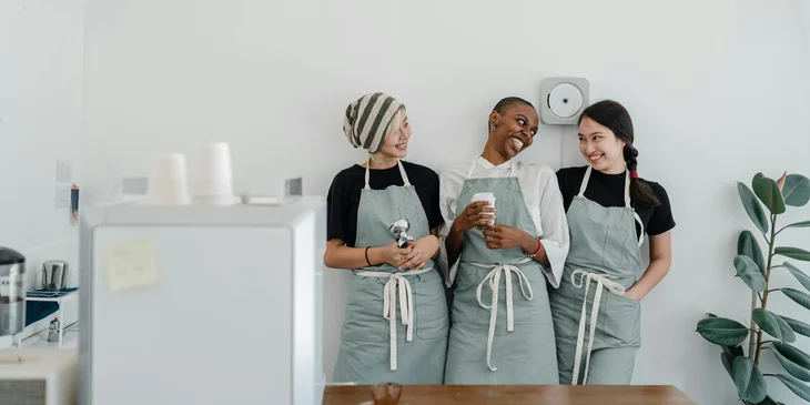 Three staff members having a conversation in the pantry.