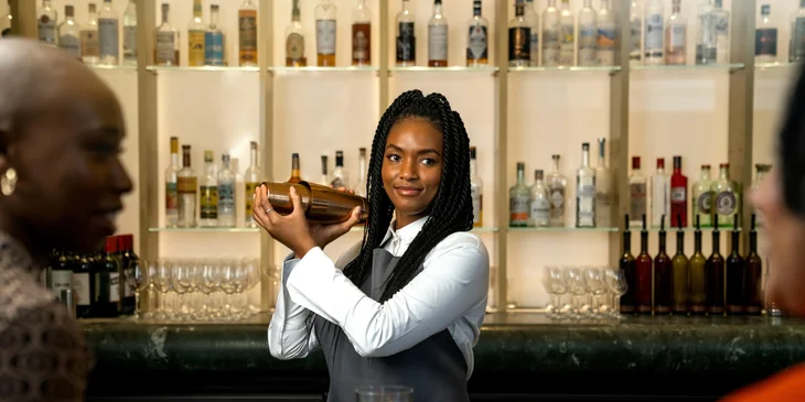 A bartender preparing drinks for the customers.
