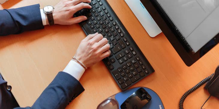 A man typing on a laptop.