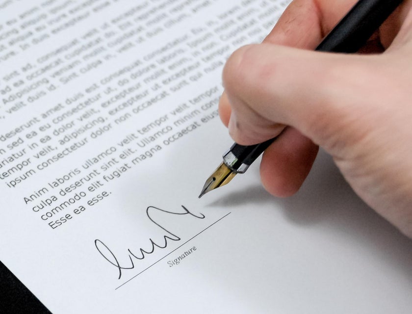 A man signing a letter of recommendation.