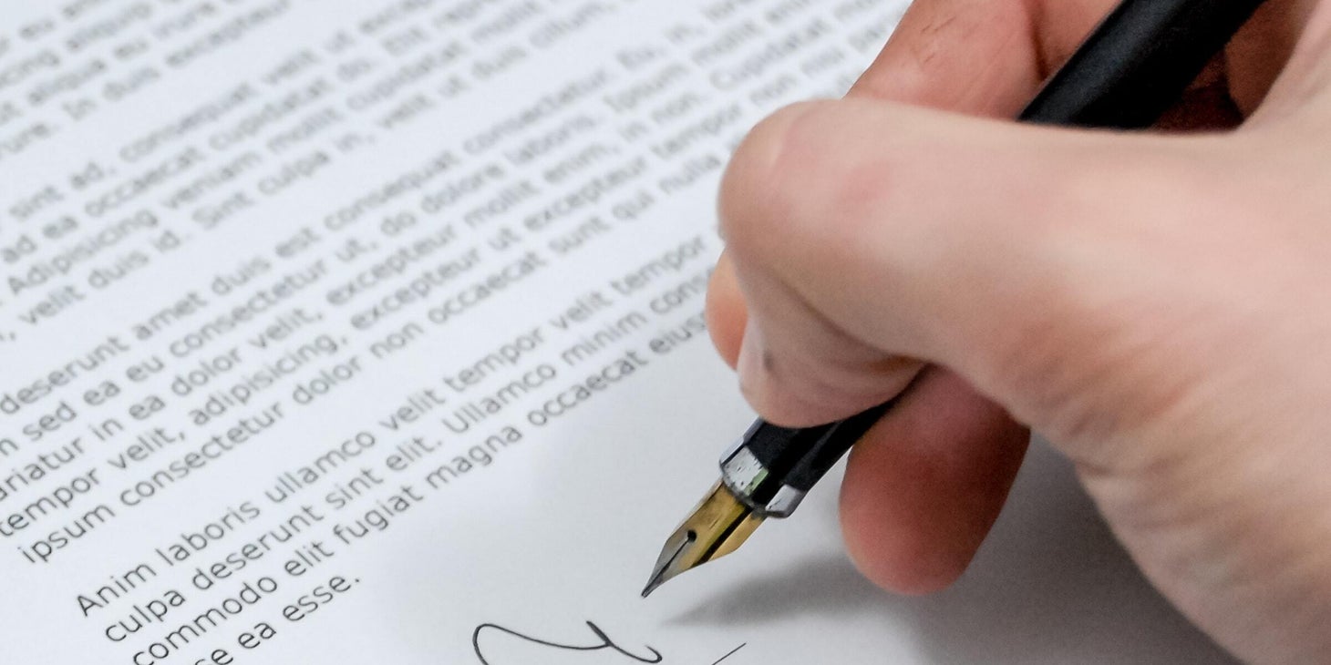 A man signing a letter of recommendation.
