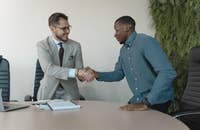Dois homens apertando as mãos em uma entrevista.